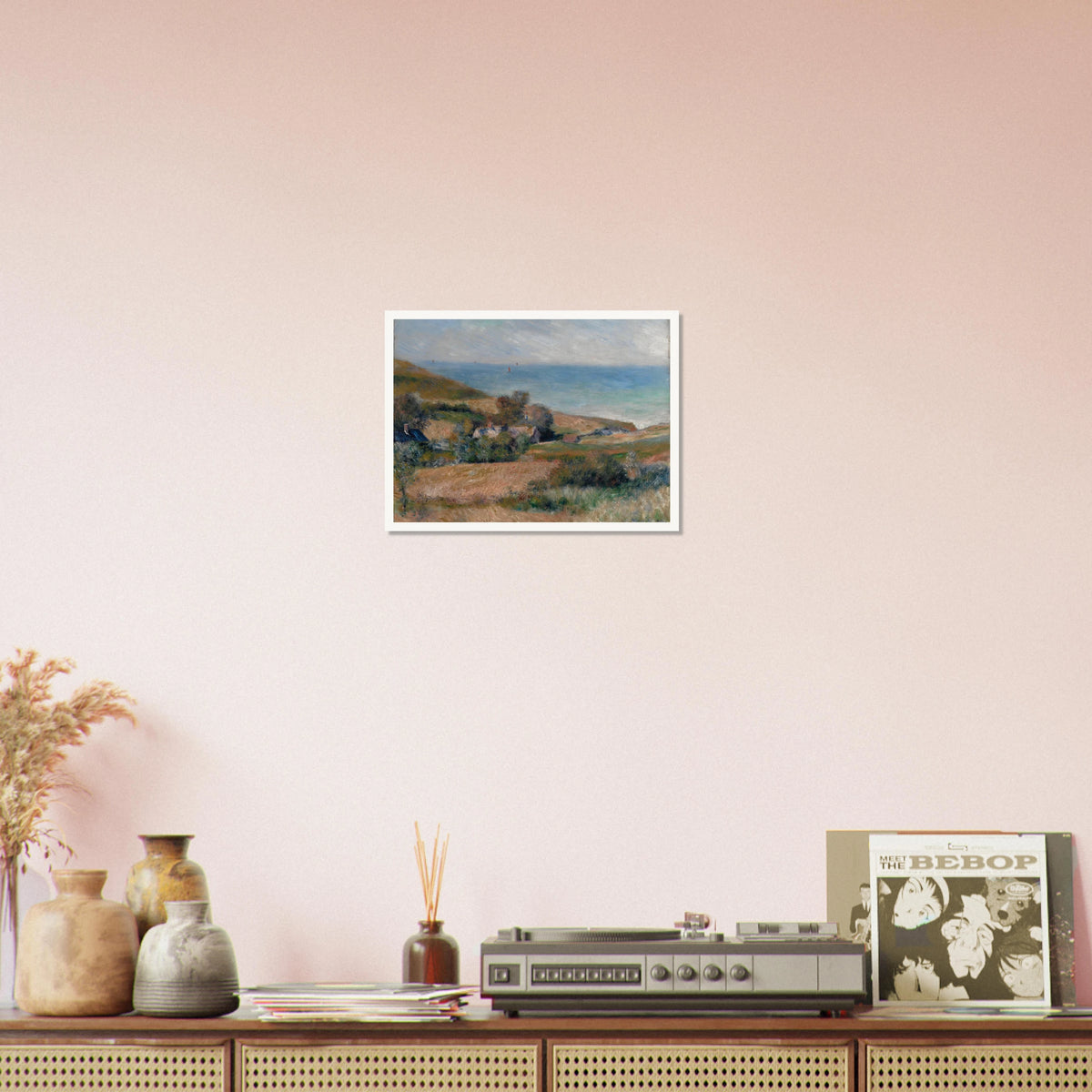 A Normandy coast with grassy fields, cottages, and a calm blue sea beneath a pale sky.