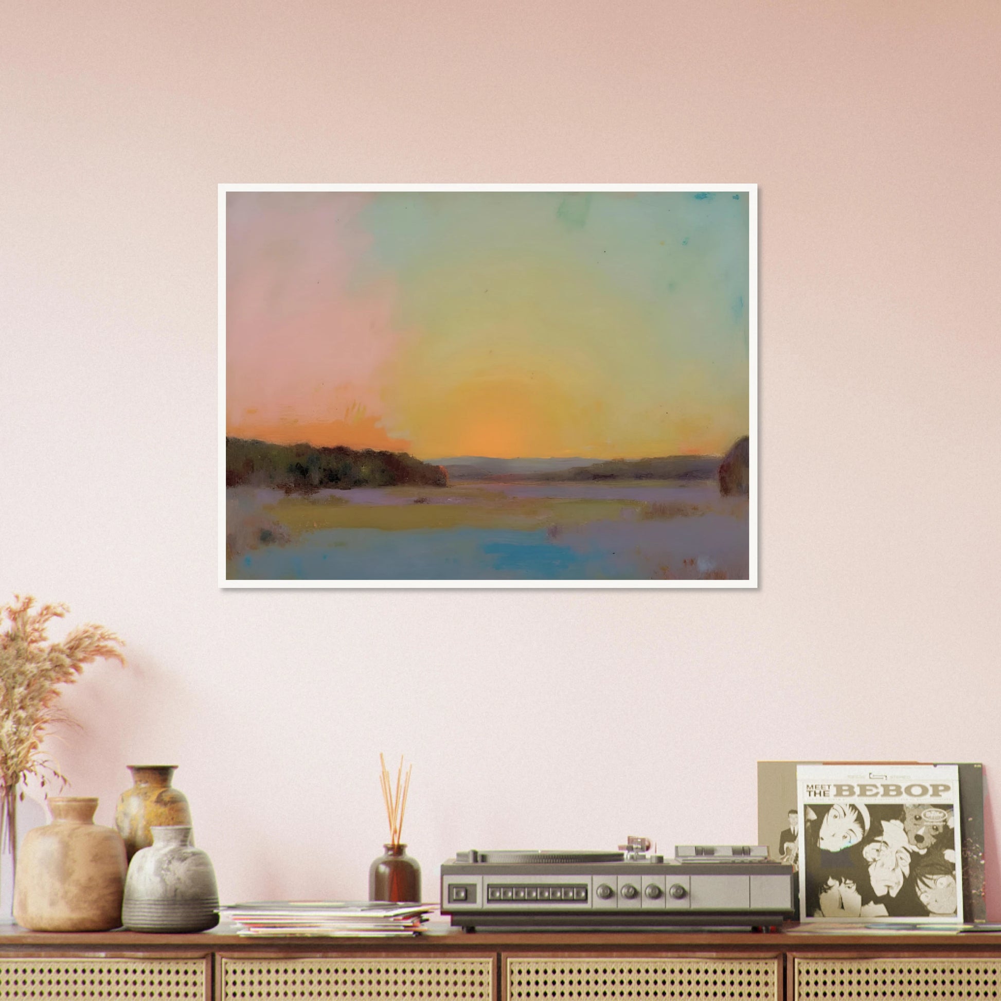 A pastel-toned sunrise casts soft pink, yellow, and blue hues over tranquil open fields bordered by distant trees.