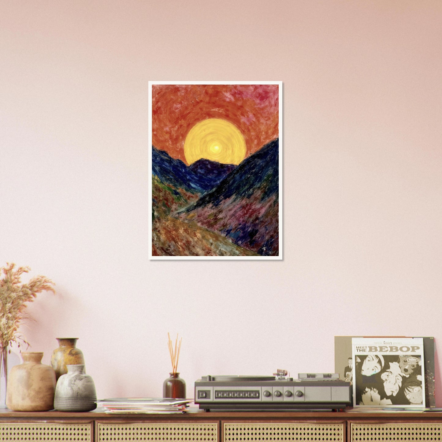 A vivid sunset over deep blue mountains with a glowing golden sun radiating warmth across the textured, colorful valley.