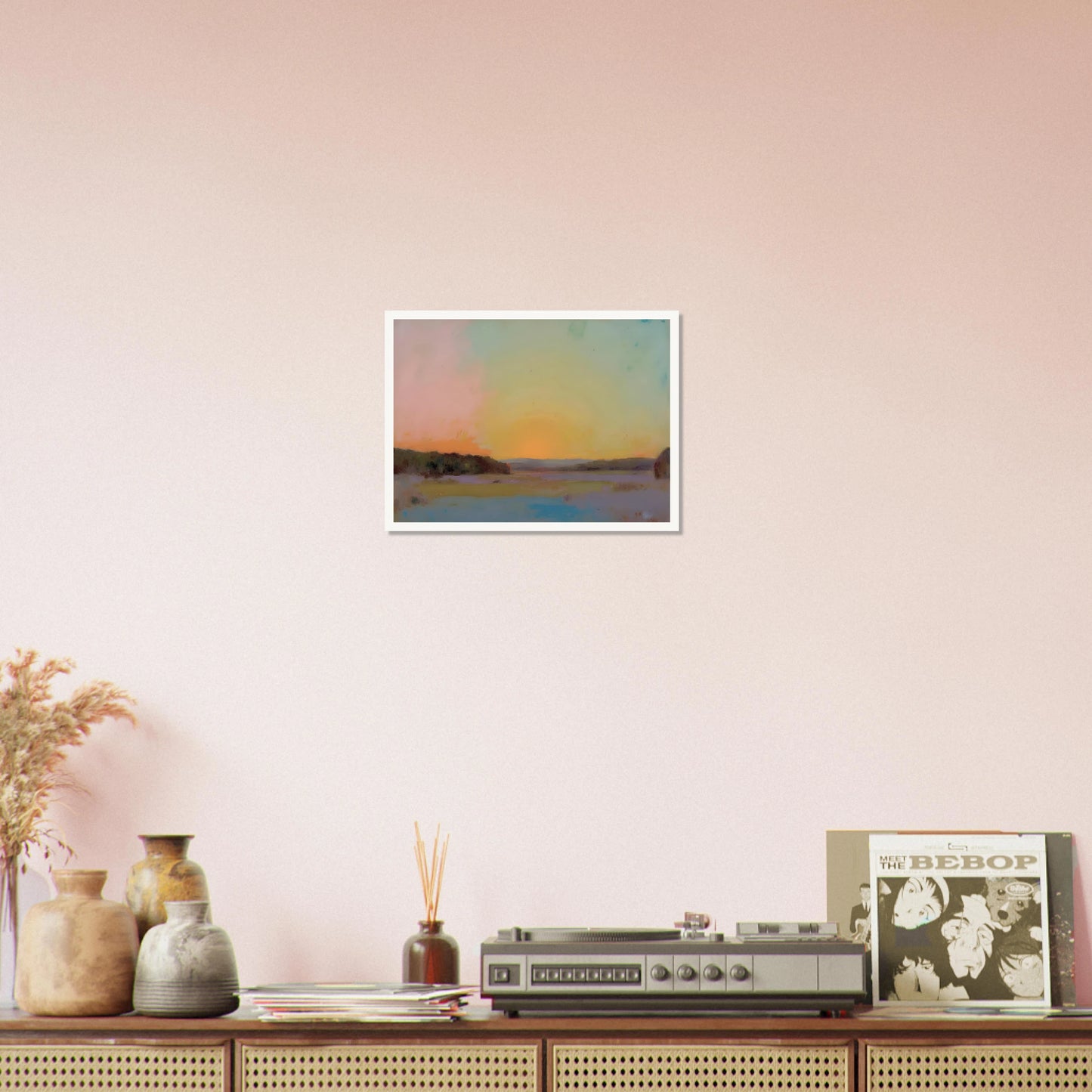 A pastel-toned sunrise casts soft pink, yellow, and blue hues over tranquil open fields bordered by distant trees.