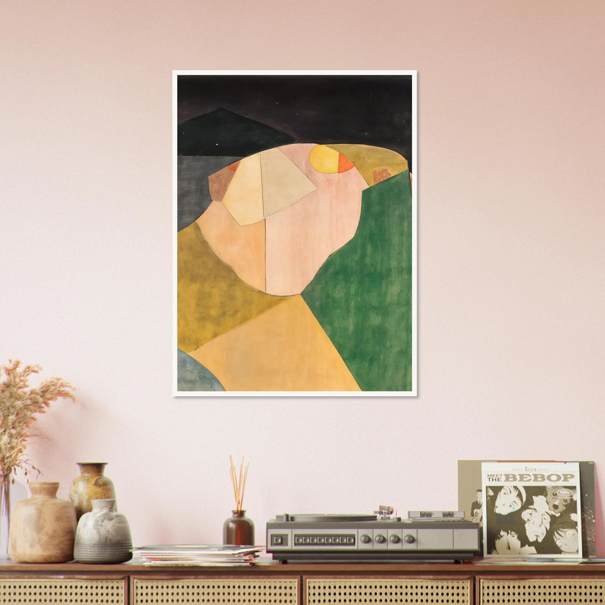 An abstract landscape of overlapping shapes in green, ochre, and pink under a dark night sky with a soft yellow moon.