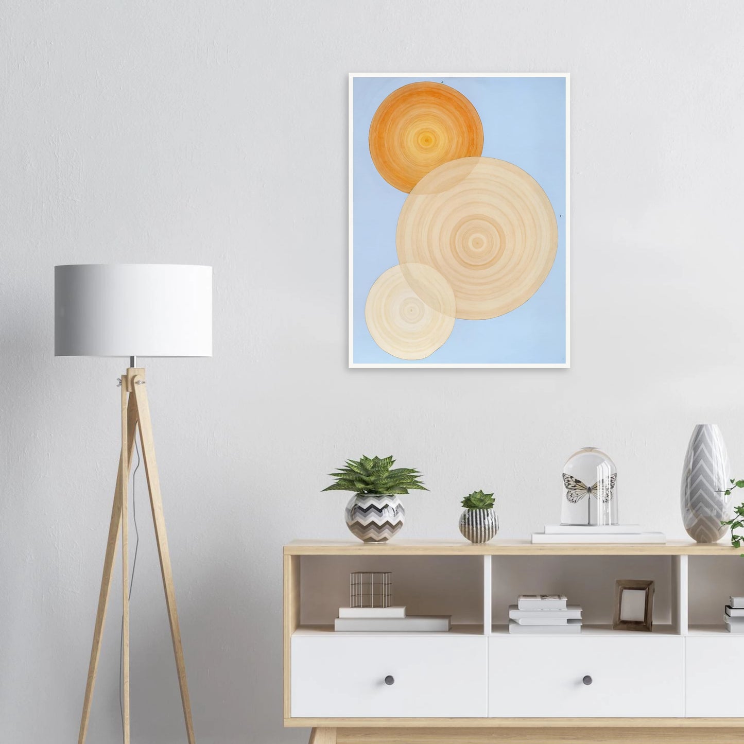 Three overlapping concentric circles in warm orange and beige tones float on a soft blue background like suns in serene orbit.