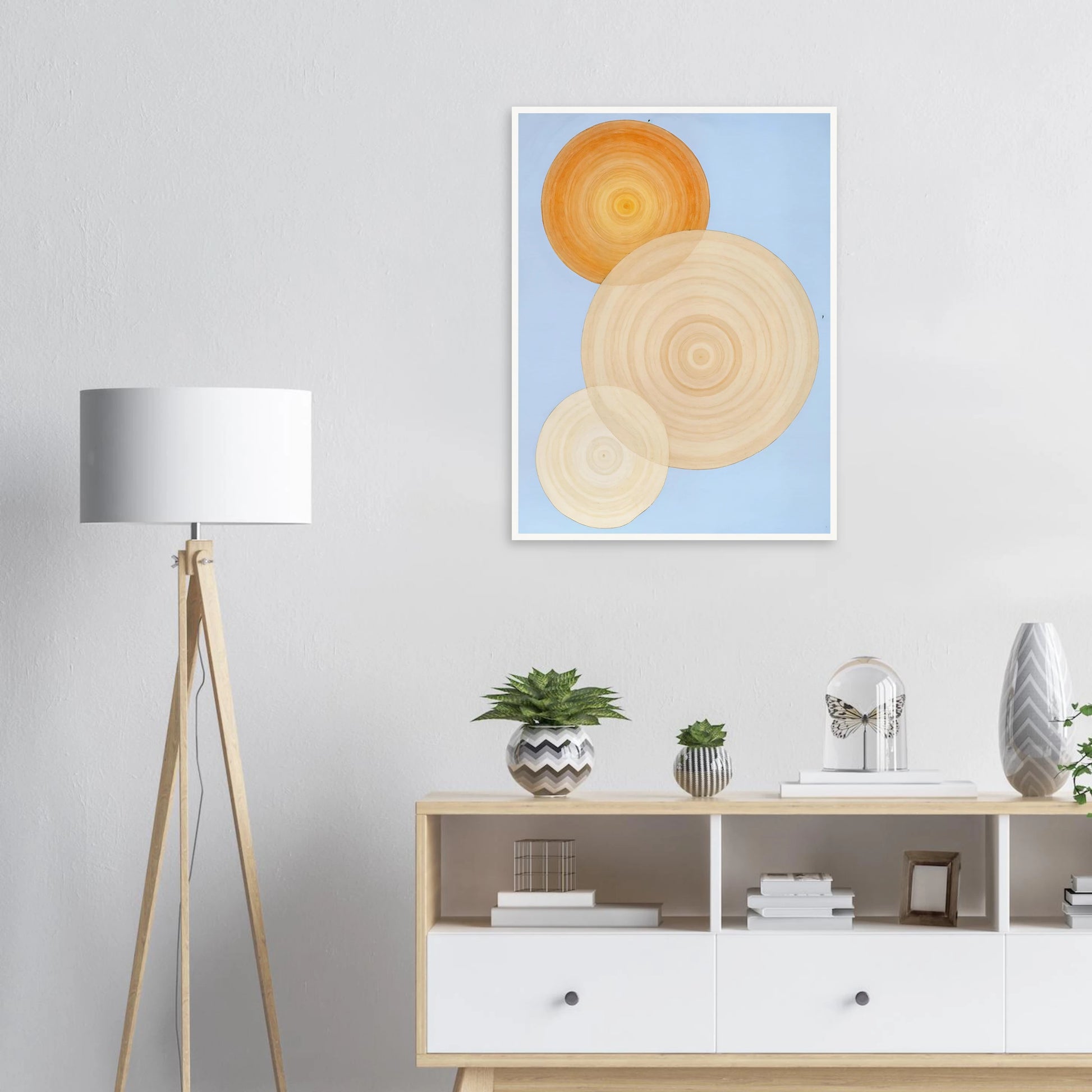 Three overlapping concentric circles in warm orange and beige tones float on a soft blue background like suns in serene orbit.