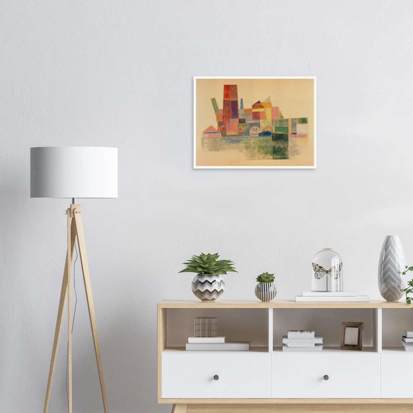 A pastel-toned cityscape made of overlapping geometric blocks in soft reds, greens, yellows, and blues against a beige backdrop.