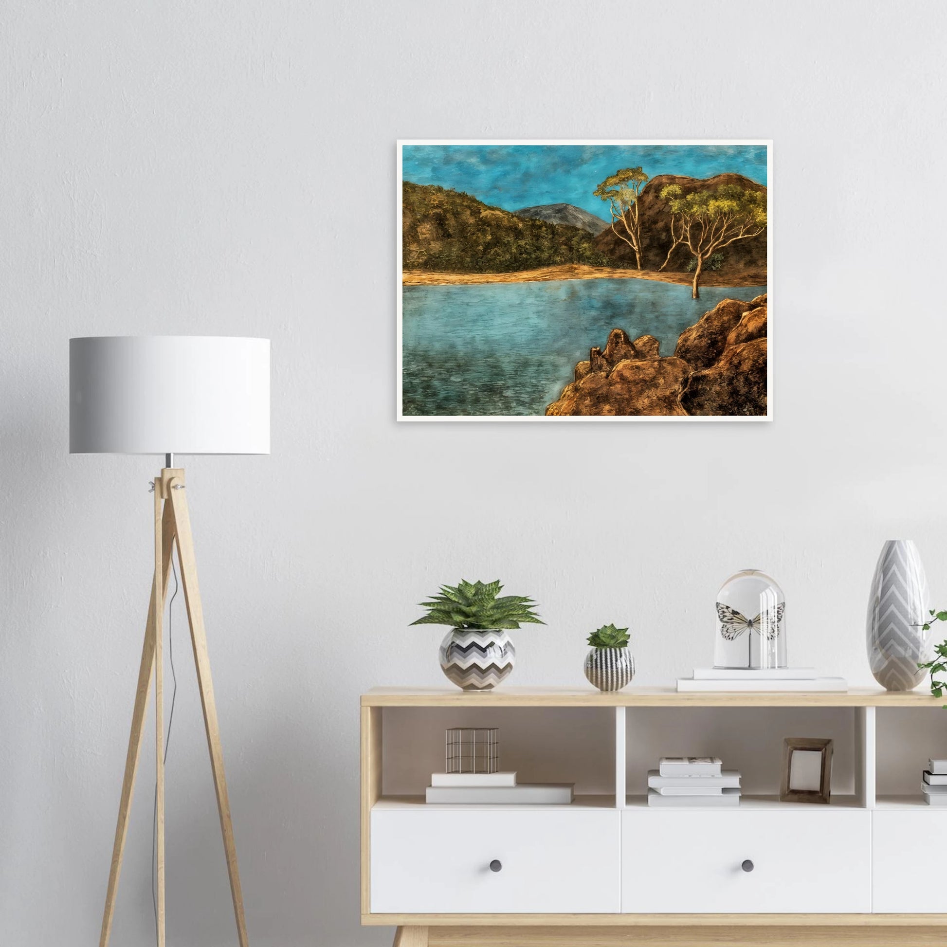Blue lake with rocky shore, brown hills, slender trees, and turquoise sky in a quiet landscape.