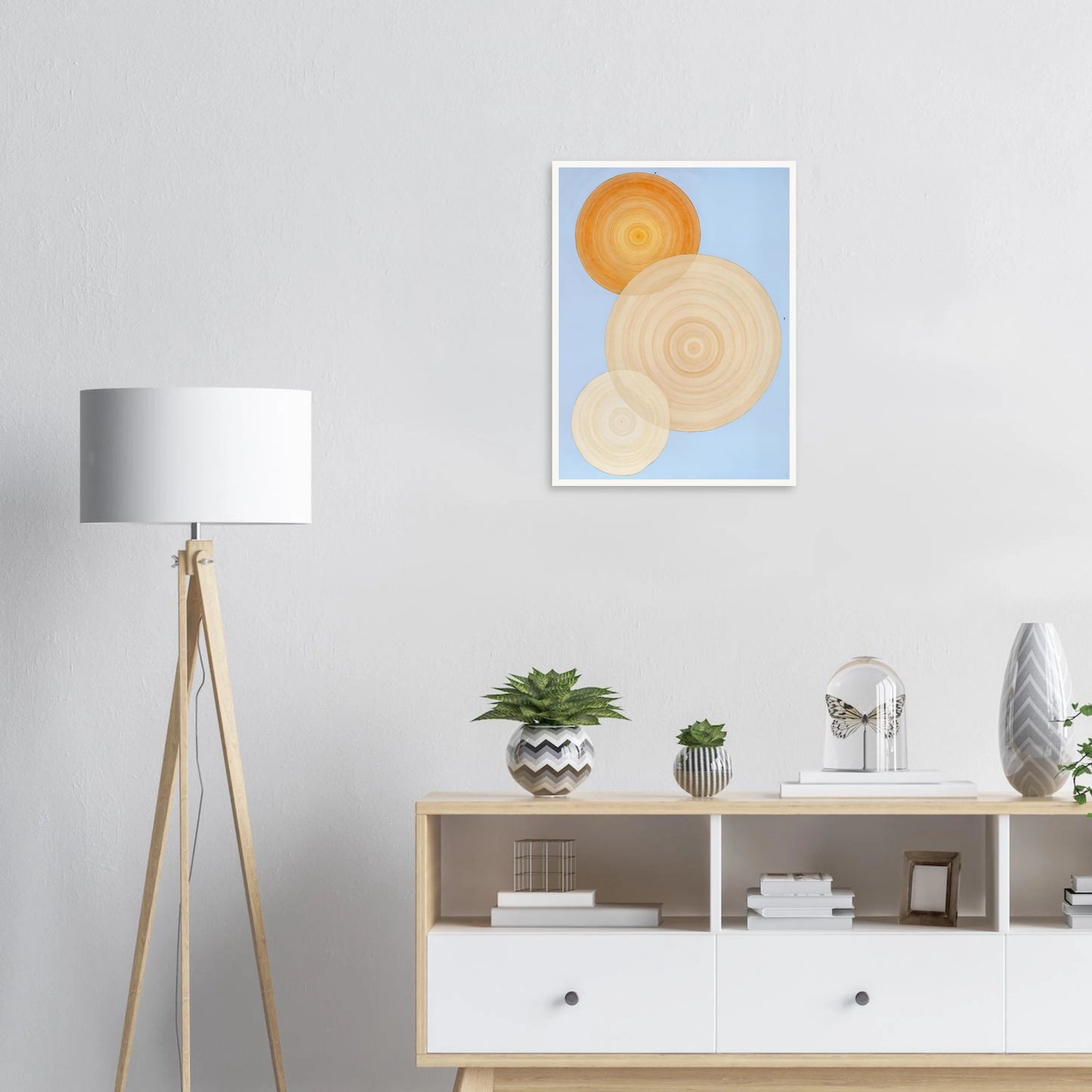 Three overlapping concentric circles in warm orange and beige tones float on a soft blue background like suns in serene orbit.