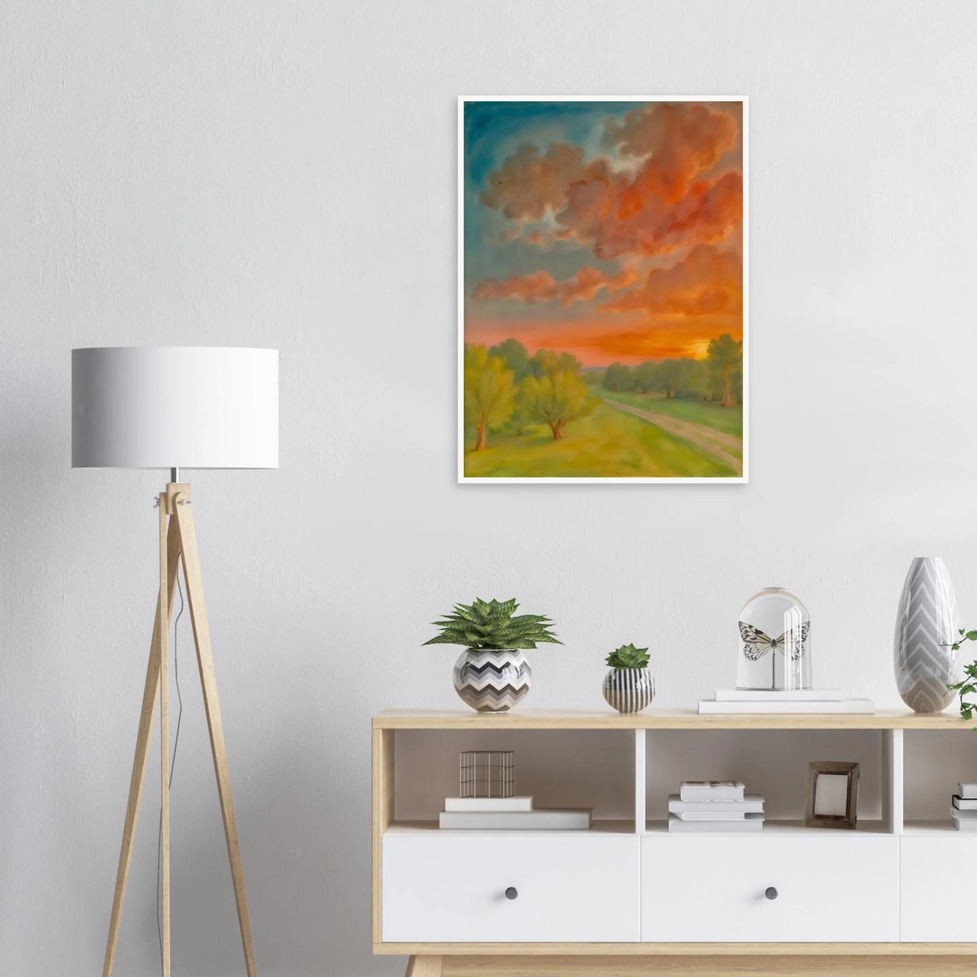 Soft orange clouds drift above a winding country path, with green trees and fading sunlight across open fields.