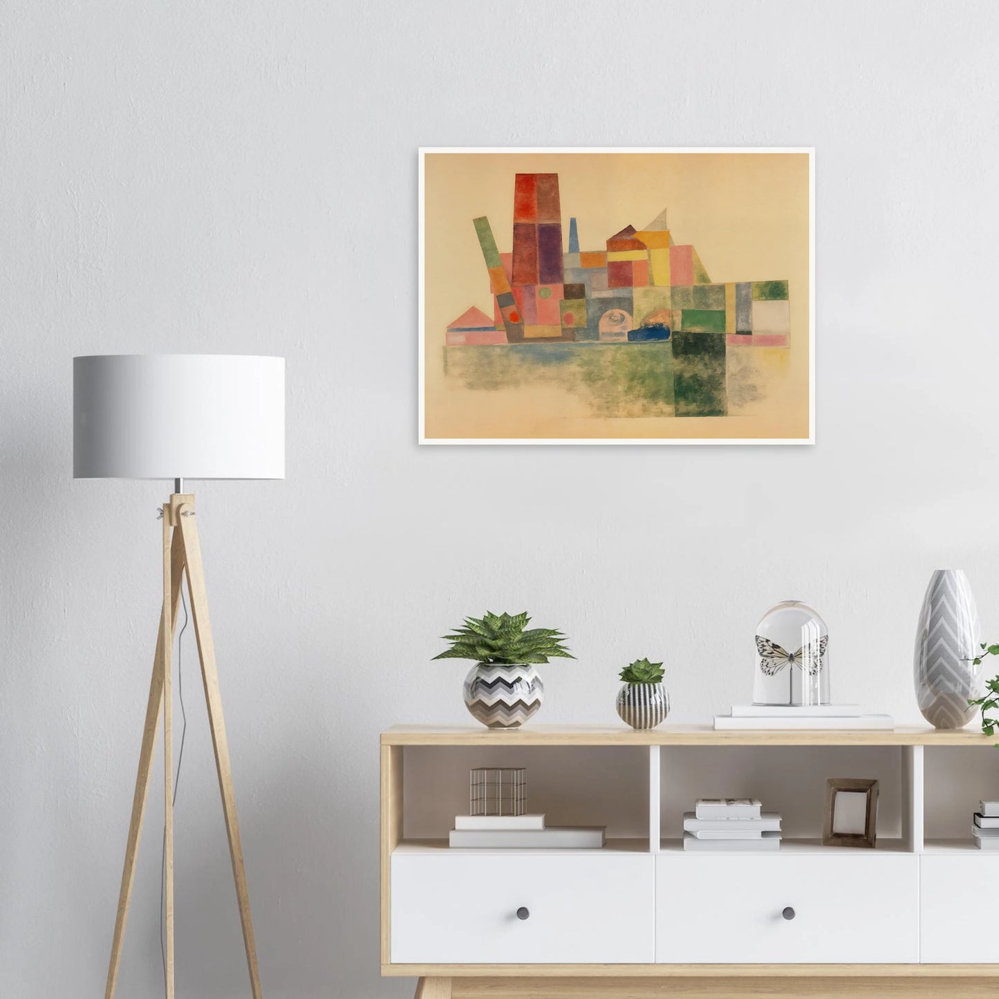 A pastel-toned cityscape made of overlapping geometric blocks in soft reds, greens, yellows, and blues against a beige backdrop.