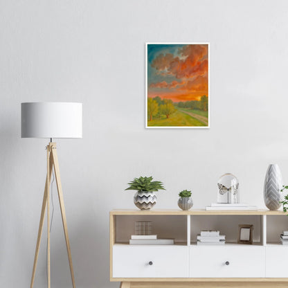 Soft orange clouds drift above a winding country path, with green trees and fading sunlight across open fields.