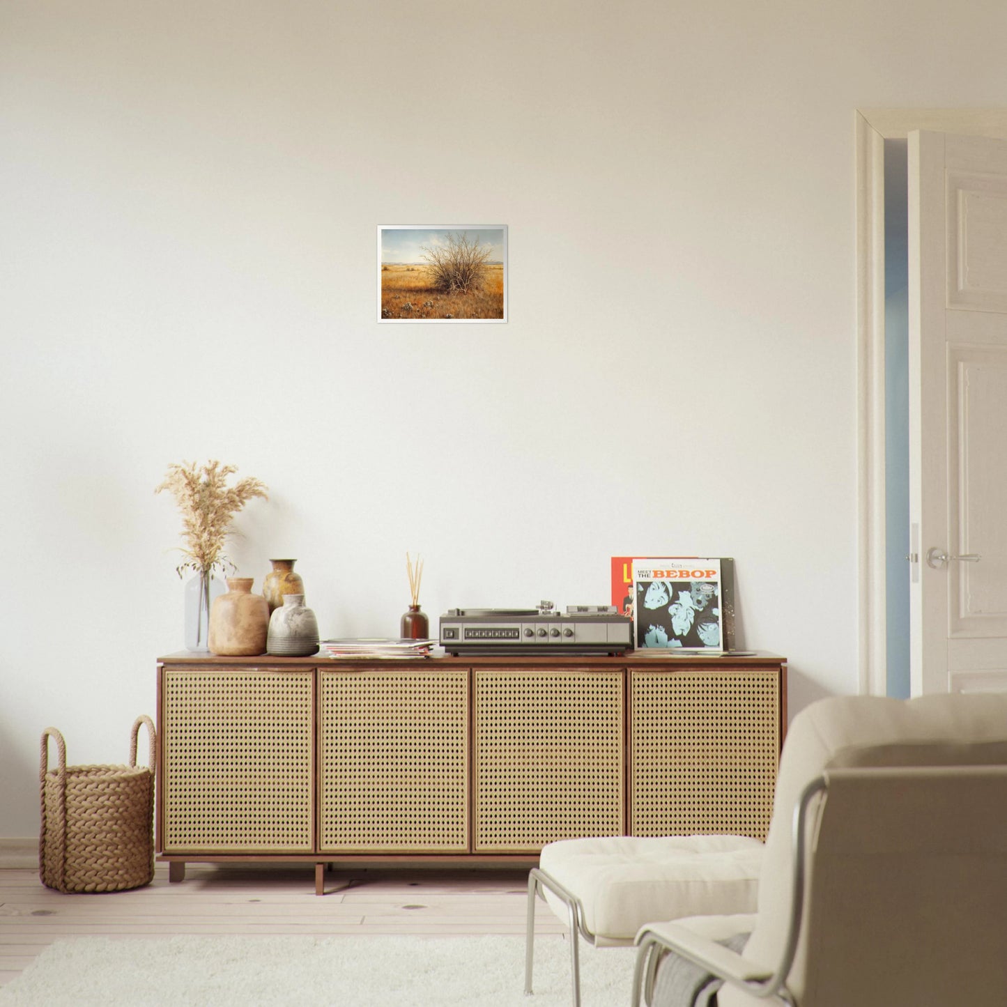 A golden-brown field stretches into the distance under a pale blue sky, with a single dry bush standing in quiet solitude.
