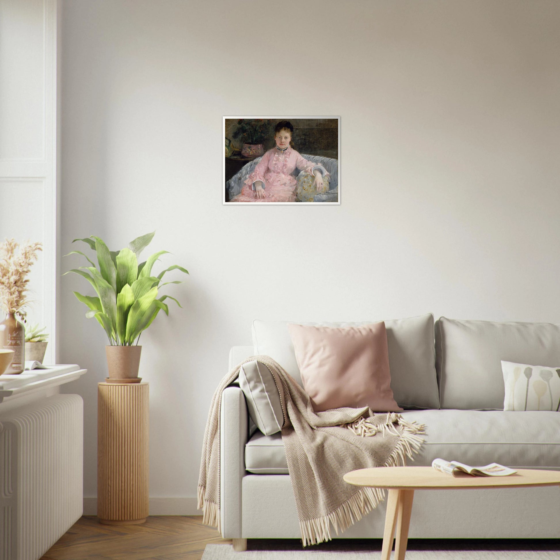 Young woman in a pink dress sits on a sofa beside flowers and a patterned pillow