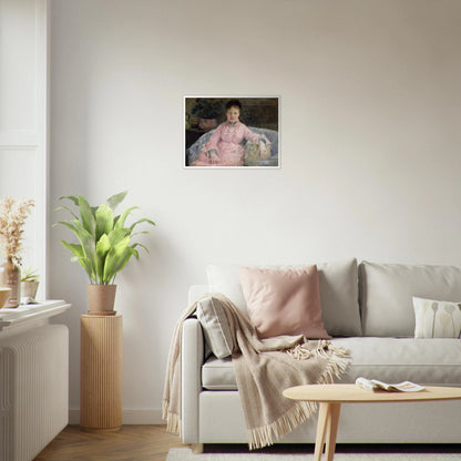 Young woman in a pink dress sits on a sofa beside flowers and a patterned pillow