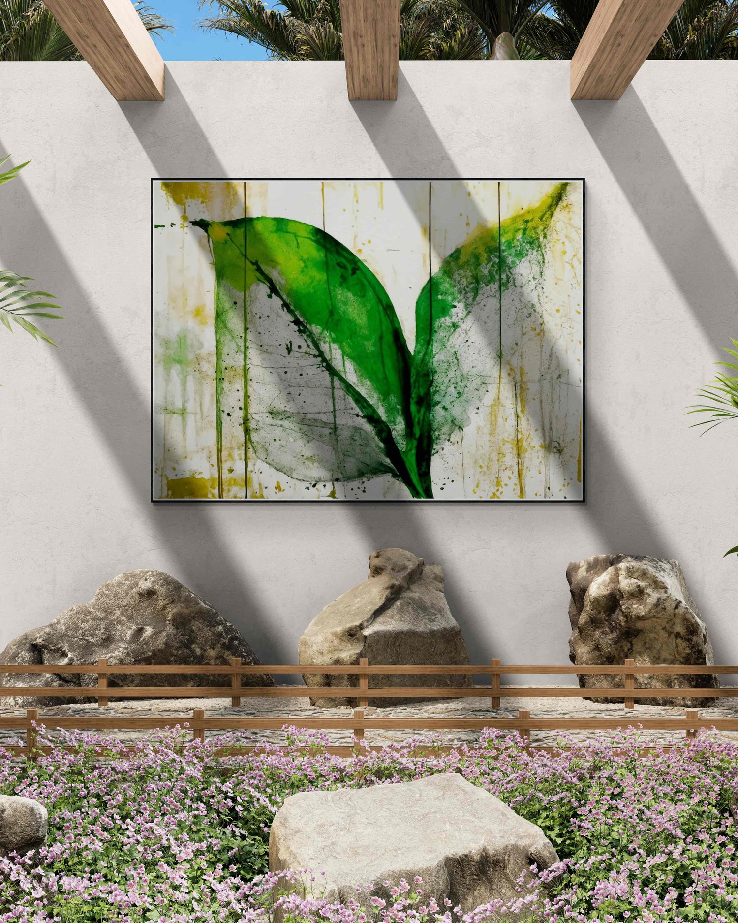 Outdoor garden with pink flowers, large rocks, and a wooden fence, featuring abstract green leaf wall art on a white wall with natural light.