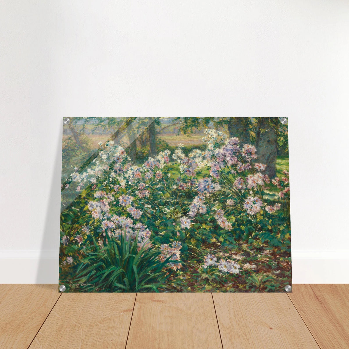 Pink and white flowers bloom densely among lush green foliage beneath tall trees in a sunlit garden.