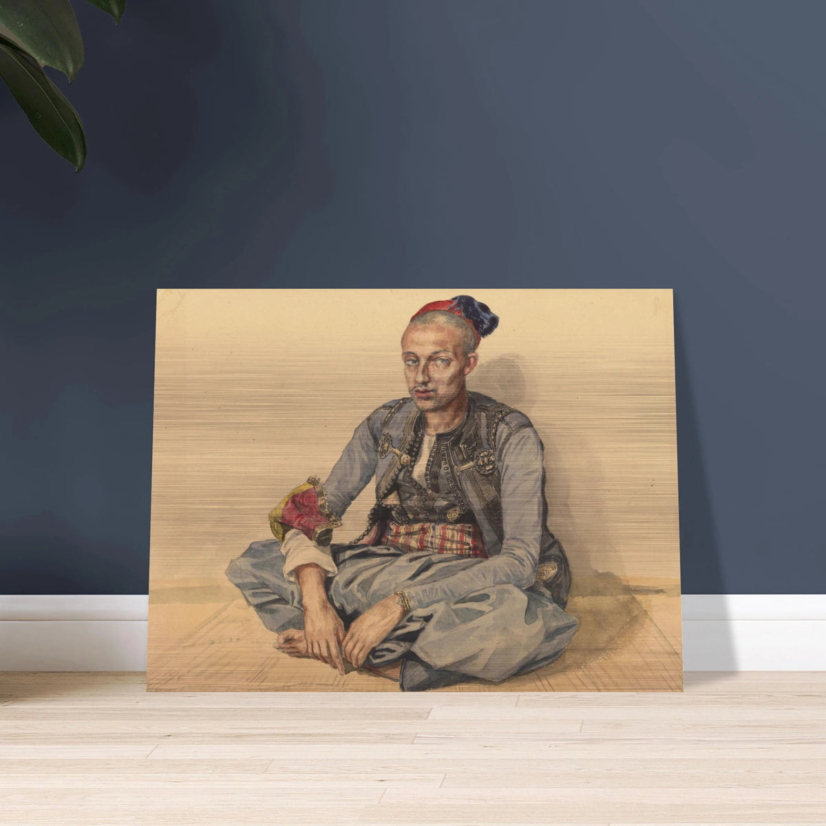 Seated artisan from Algiers in blue robes and a red cap, wearing a patterned sash and ornate accessories.