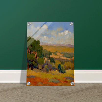 Golden fields and green trees stretch beneath a blue sky with soft clouds and distant hills.