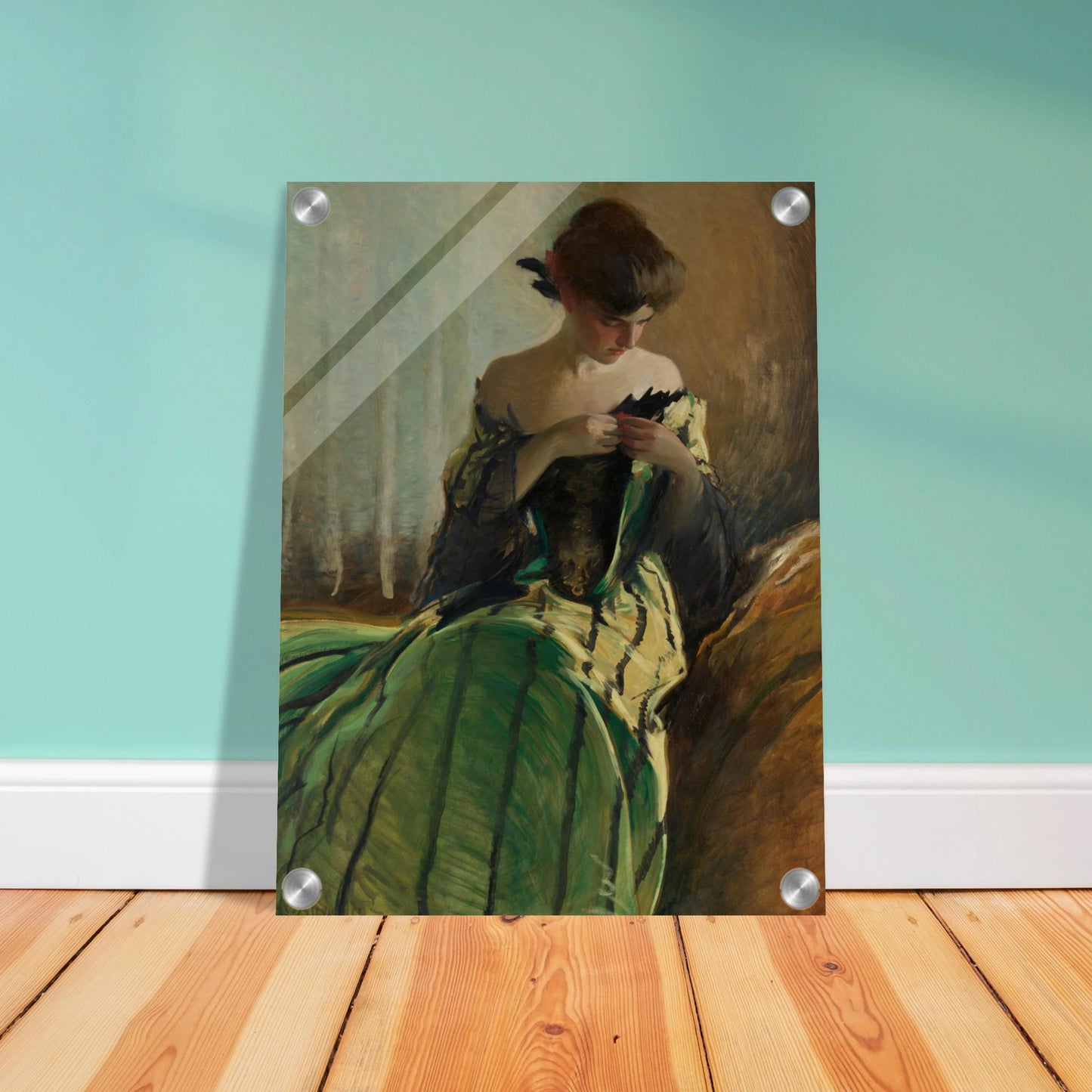 Woman in green and black evening gown pins a detail at her neckline against a muted background