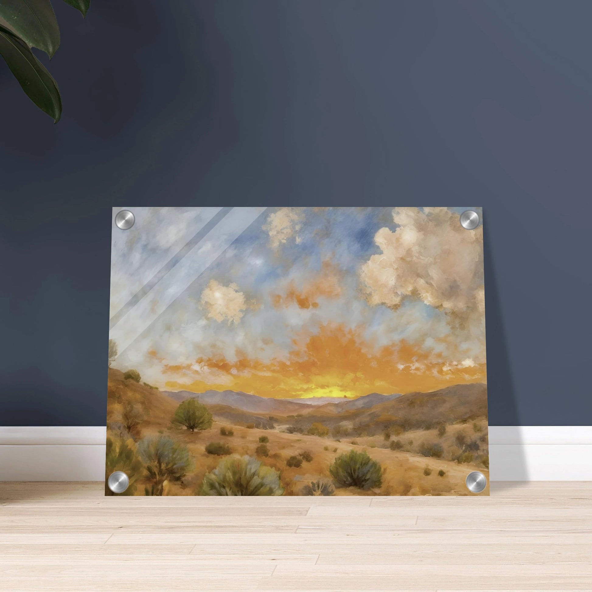A glowing orange sunset spreads over a tranquil desert valley with scrubby bushes, rolling hills, and dramatic cloud cover.