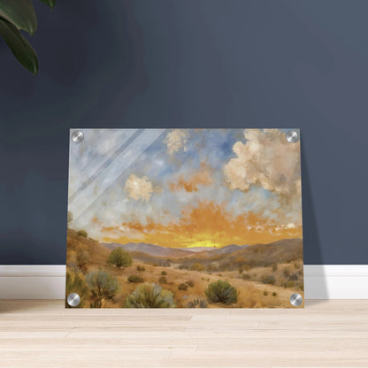 A glowing orange sunset spreads over a tranquil desert valley with scrubby bushes, rolling hills, and dramatic cloud cover.