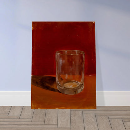 Transparent drinking glass casting a soft shadow on a warm orange and red background.