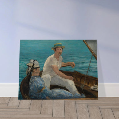 Man and woman sit in a small boat on bright blue water under a gray sail