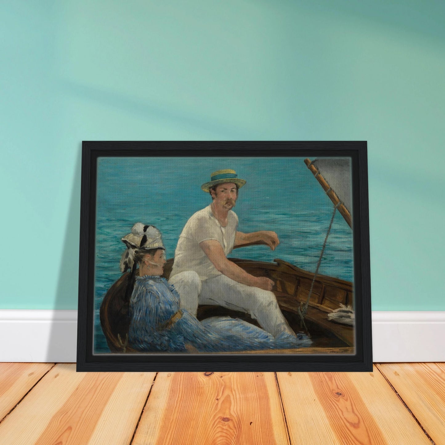 Man and woman sit in a small boat on bright blue water under a gray sail