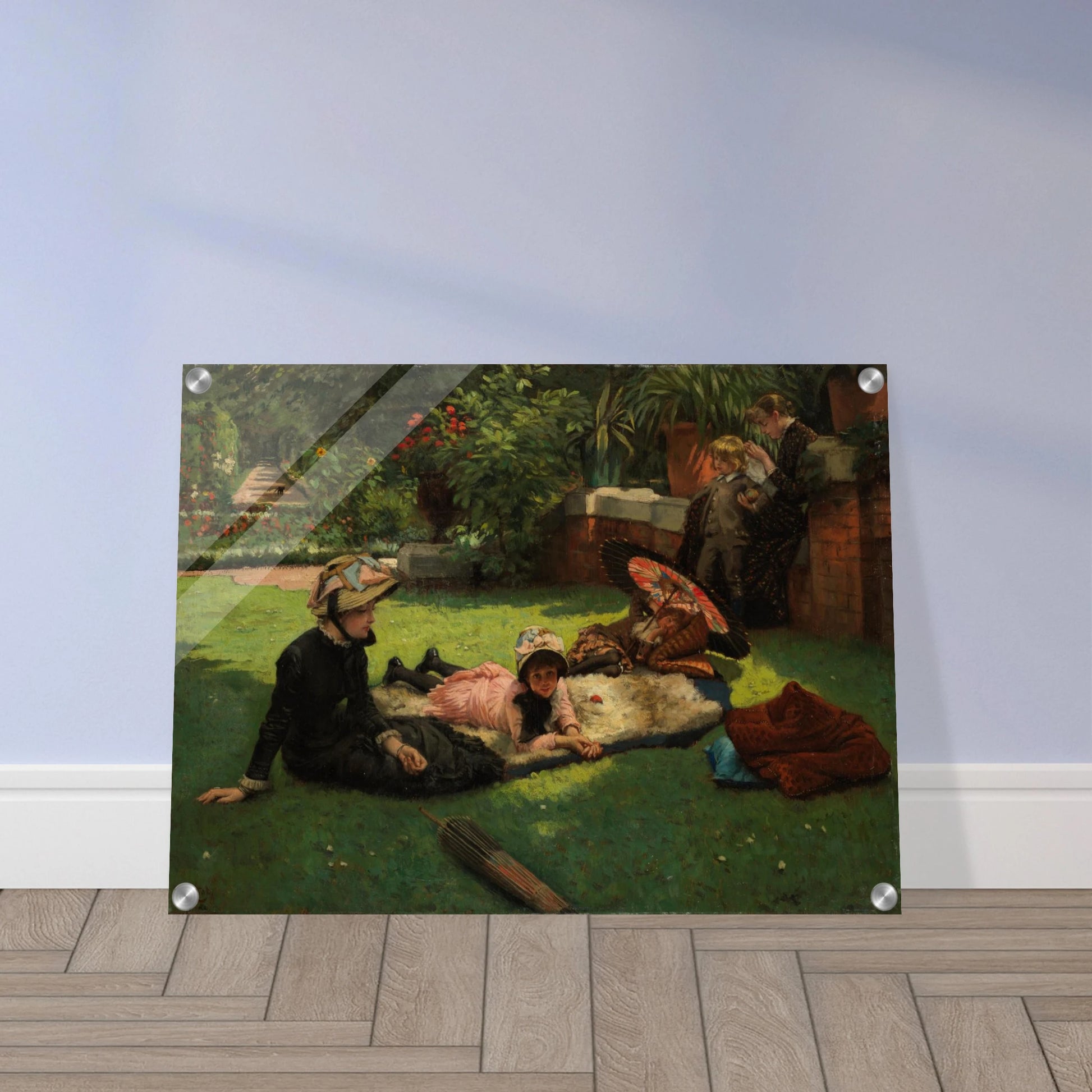 Children and women lounge in a garden with a colorful parasol under bright sunlight