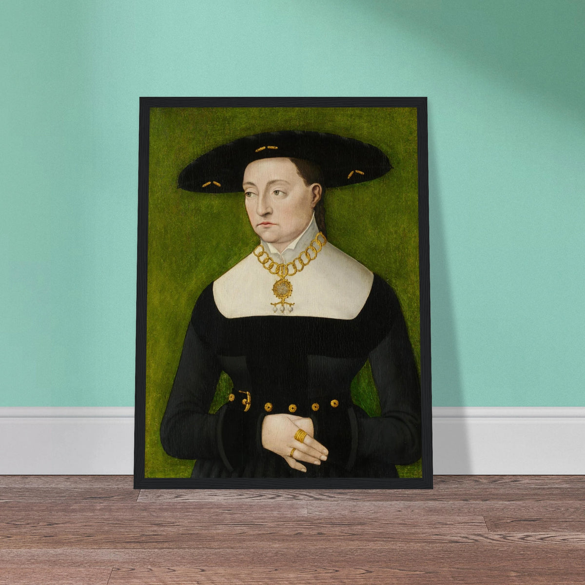 A woman in a black dress and broad hat poses against a green background with gold jewelry.