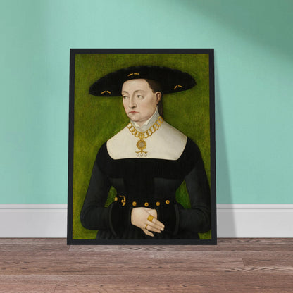 A woman in a black dress and broad hat poses against a green background with gold jewelry.